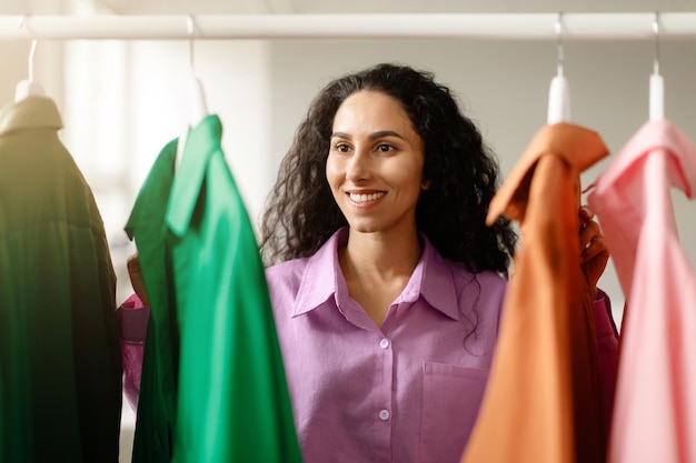 Dame winkelen kijken naar kleding op rek in kledingwinkel