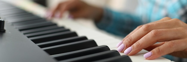 Dames hand aanraken van witte en zwarte toetsenborden op piano