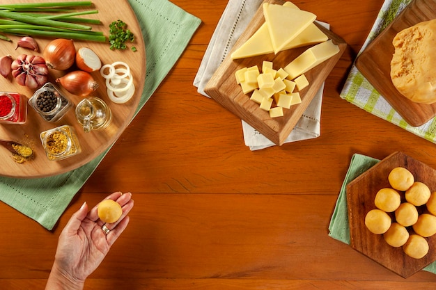 Dames hand met Braziliaanse kaas gevulde kroket bolinha de queijo op een houten tafel Bovenaanzicht