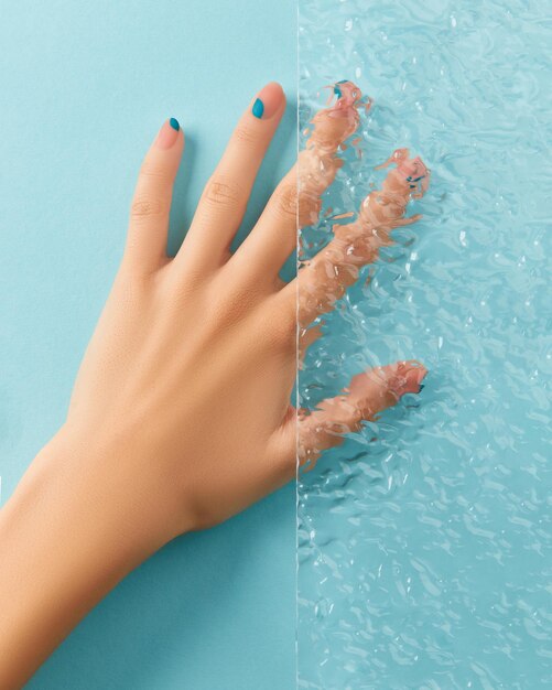 Dames hand met manicure op blauwe achtergrond schoonheidsbehandeling concept