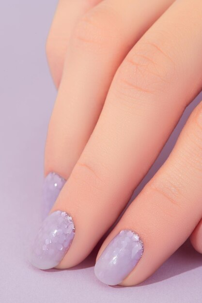 Dames hand met modieuze lavendel manicure Lente zomer nagel ontwerp Schoonheidssalon concept