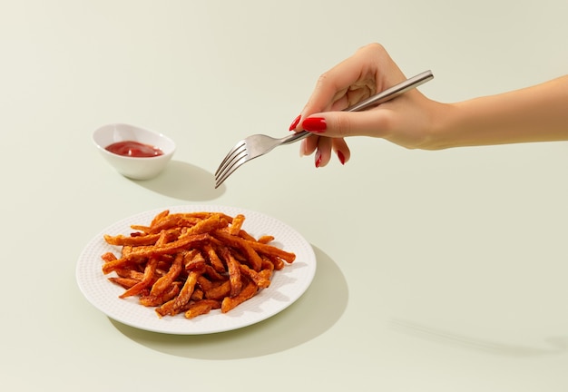 Dames hand neemt zoete frietjes op groene tafel