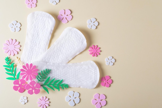 Dames maandverband voor de menstruatieperiode versierd met bloemen op een gele achtergrond