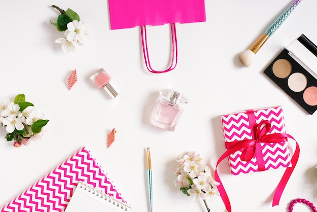 Damesaccessoires en cosmetica op een wit bureaublad met een geschenkdoos Flat lay fashion blogger
