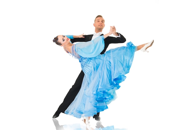 Dance ballroom couple in red dress dance pose isolated on black background. sensual professional dancers dancing walz, tango, slowfox and quickstep. bue dress and tuxido