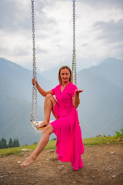 Dance with a swinging sun by a girl in a pink dress on a swing