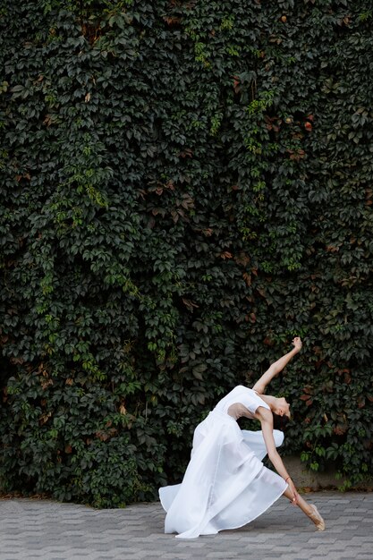 Dancer ballerina in white dress outside