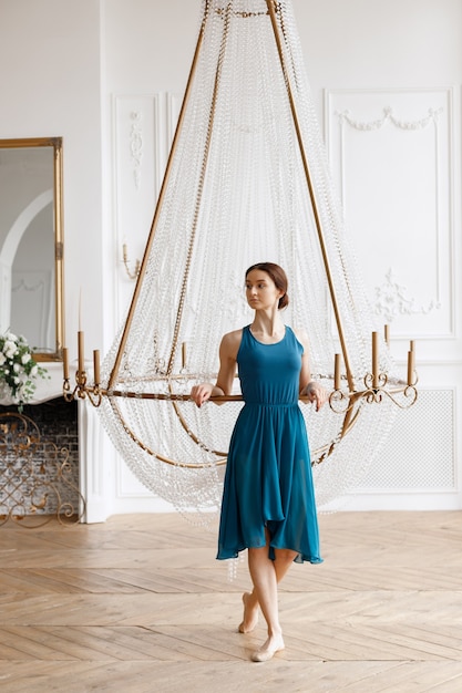 Dancer in ballet shoes at the crystal chandelier