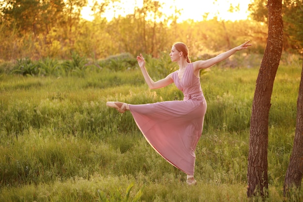 A dancer dances in a dress at sunset in nature dance school banner