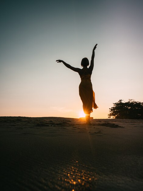 Dancer girl on the beach in sunset