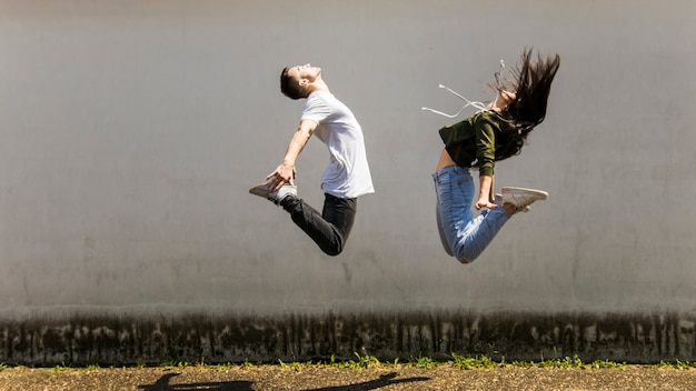 Photo dancer jumping in air against gray wall