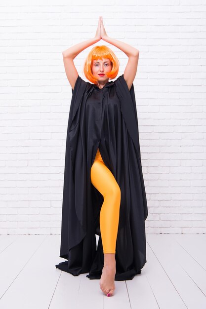 Dancer lifestyle. Stop hiding bright energy. Feel your body. Dancing theatre performer. Dancing in cloak. Girl with long fit legs orange tights dancing. Woman ginger wig performing modern art dance.