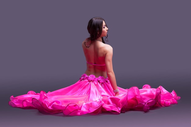 Dancer in pink costume sitting on floor