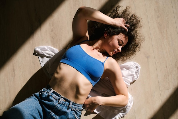 Dancer young girl in casual clothes dancing contemporary dance
indoors the hall in morning sun lights