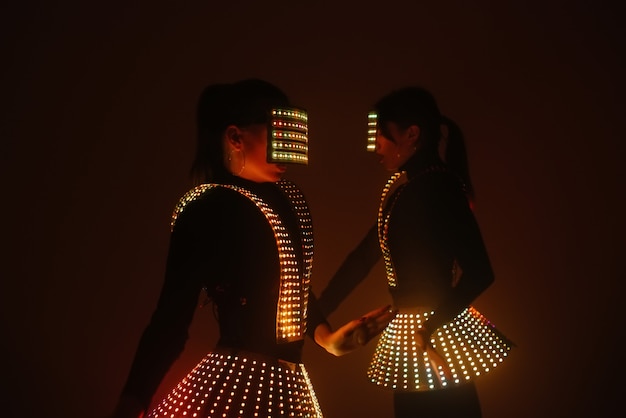 Dancing girls in bright and colorful luminous costumes.