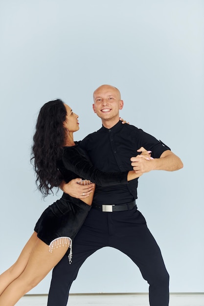 Dancing in the studio with white background Cheerful couple is together indoors