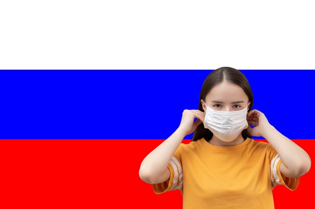 The danger of coronavirus in russia young girl in antibacterial medical mask on a flag background with copyspace