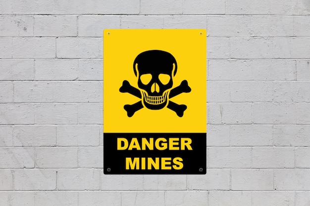 Danger mines sign on a cinder block wall