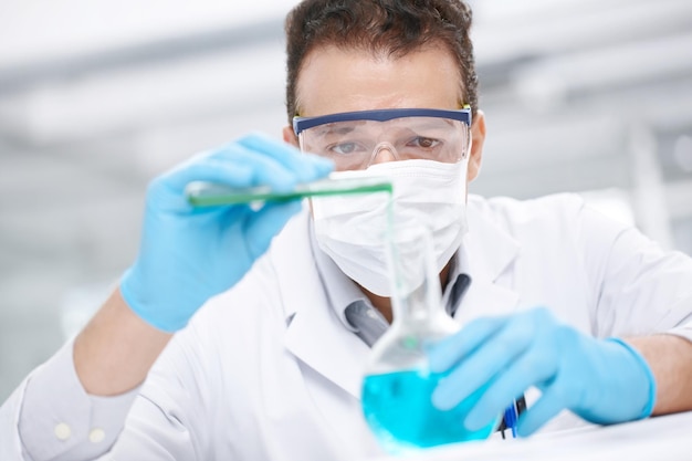 Dangerous experiment Closeup of a chemist pouring two chemicals together