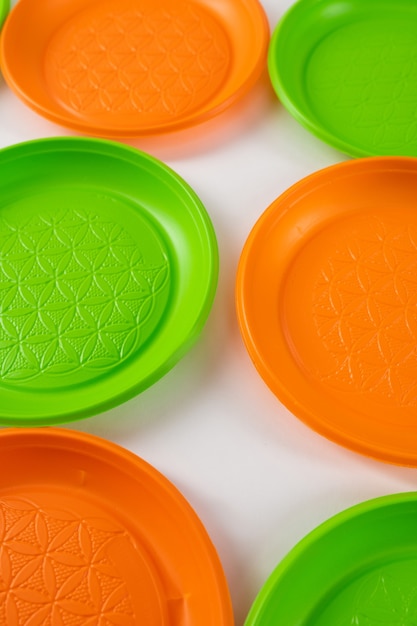 dangerous green and orange disposable plates made of harmful plastic and causing ecological catastrophe