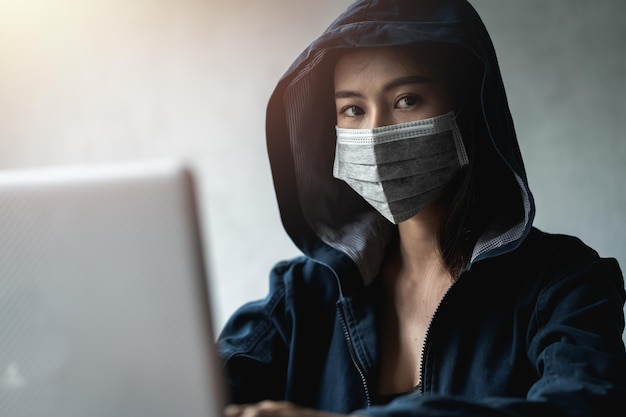 Dangerous hooded hacker che utilizza computer e virus infetti ransomware per hackerare dati personali e finanziari. criminalità informatica, informatica, posta di phishing.