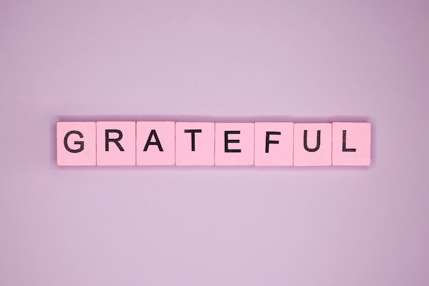 Dankbaar woord op roze tafel