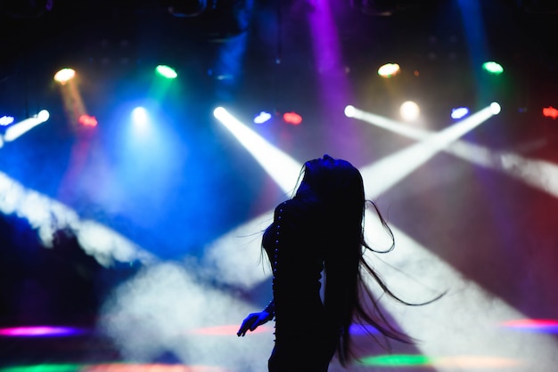 Dansend silhouet van meisje in een nachtclub