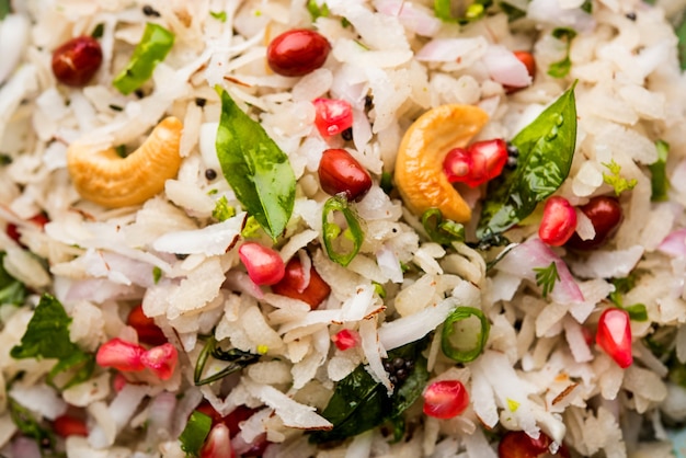 Dapde Pohe is a typical Maharashtrian breakfast, made with thin variety of poha and fresh coconut with chilli, peanuts and nuts. served in a bowl or plate. selective focus