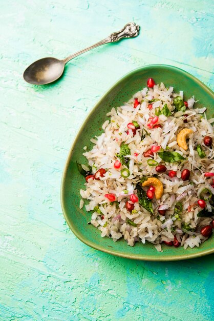 Dapde Pohe is a typical Maharashtrian breakfast, made with thin variety of poha and fresh coconut with chilli, peanuts and nuts. served in a bowl or plate. selective focus