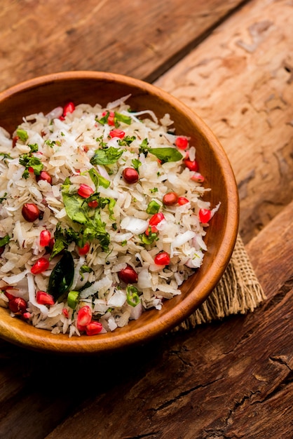 Dapde Pohe is a typical Maharashtrian breakfast, made with thin variety of poha and fresh coconut with chilli, peanuts and nuts. served in a bowl or plate. selective focus