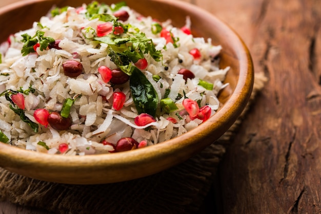 Dapde Pohe is a typical Maharashtrian breakfast, made with thin variety of poha and fresh coconut with chilli, peanuts and nuts. served in a bowl or plate. selective focus