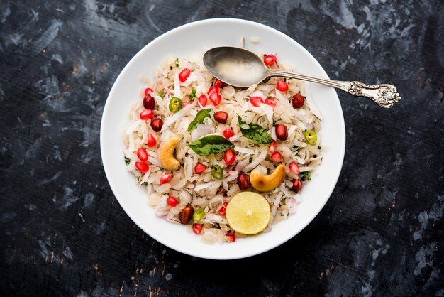 Dapde Pohe is a typical Maharashtrian breakfast, made with thin variety of poha and fresh coconut with chilli, peanuts and nuts. served in a bowl or plate. selective focus