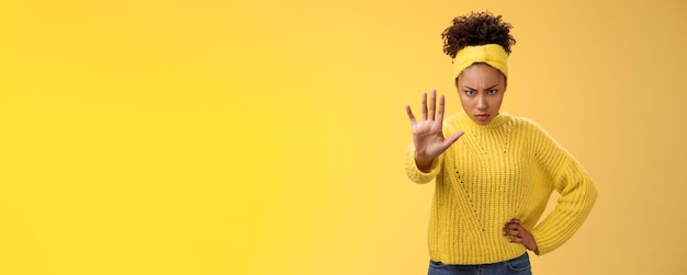 Foto dappere serieus uitziende vrouwelijke afro-amerikaanse femenist kijkt van onder het voorhoofd zelfverzekerde krachtige po