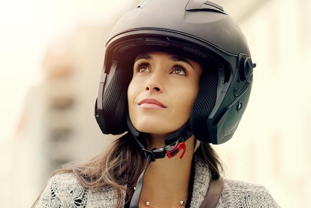 Dare to follow your dreams Closeup shot of an attractive young woman wearing a helmet and riding her scooter through the city