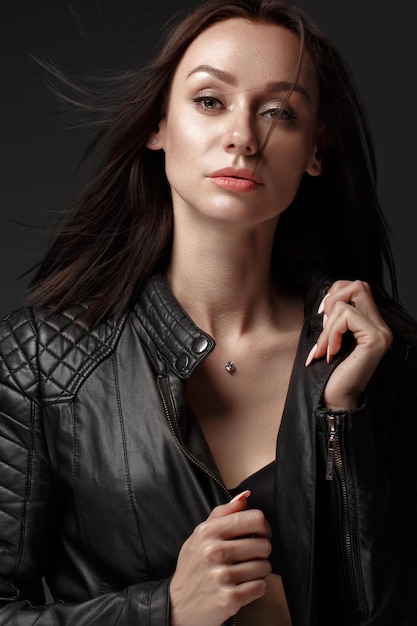 Daring girl model in black leather dress style of rock dark make up and beauty hair