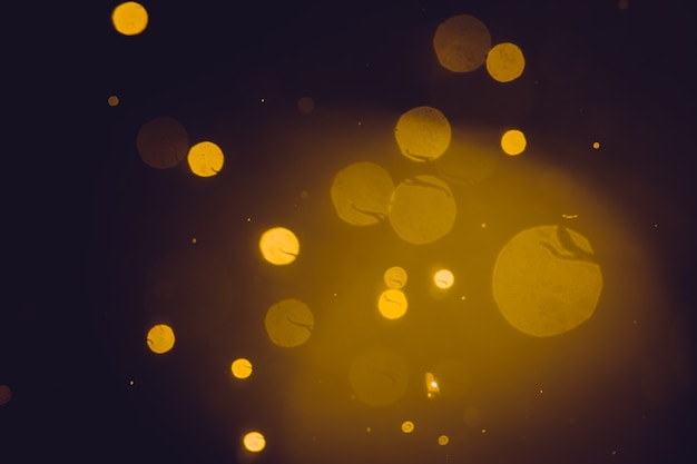 Dark Abstract Gold bokeh sparkle on black background