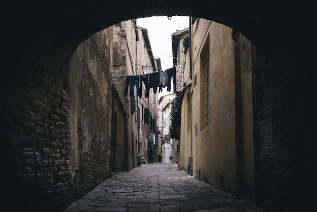 Dark alleyway with clothes hanging in Siena Tuscany Italy