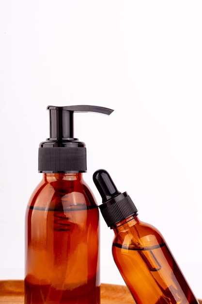 dark amber glass bottle serum wooden plate natural skin care spa beauty product design mineral organic oil cosmetics on white background mockup oily pipette face and body treatment flat layxa