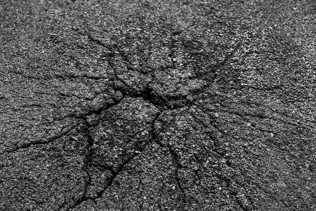 사진 균열이 있는 어두운 아스팔트 도로 지면 균열 텍스처의 배경