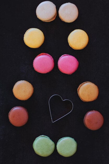 dark background. 8 of sweet candies. Colorful macaroons. Spring postcard. Woman's Day. Flat lay, top