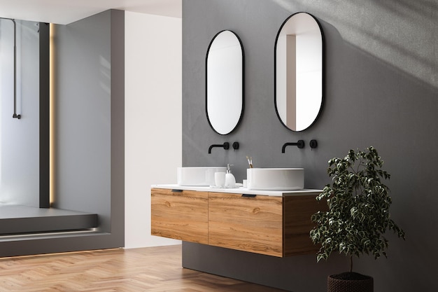 Dark bathroom interior with hardwood parquet floor, black bathtub and double sink with white counter