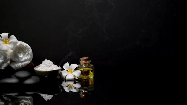 Dark beautiful spa composition with spa accessories on black table