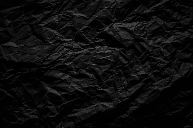 Dark black crumpled paper close up texture