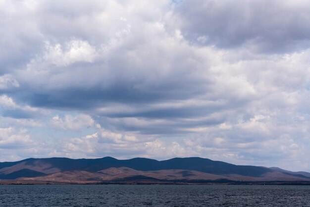 Dark blue clouds and sea or ocean water surface with dramatic seascape