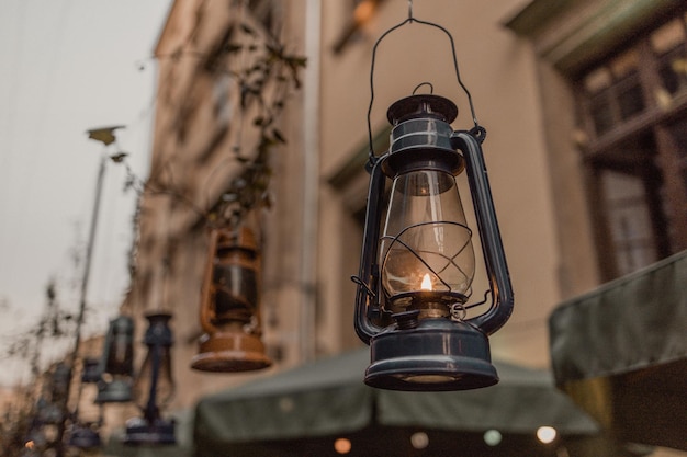 Foto decorazione di una lampada a cherosene blu scuro con illuminazione drammatica appesa alla strada della città la sera