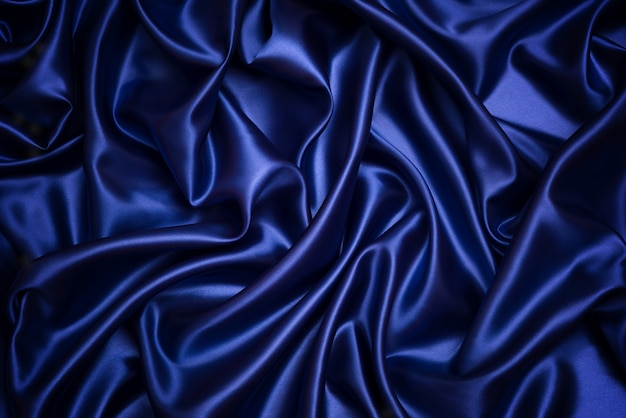 Foto fondo e struttura del raso blu scuro, scanalato dell'estratto blu del tessuto
