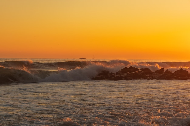 Dark blue waves against the beautiful orange sunset at the Black Sea, Anapa, Russia