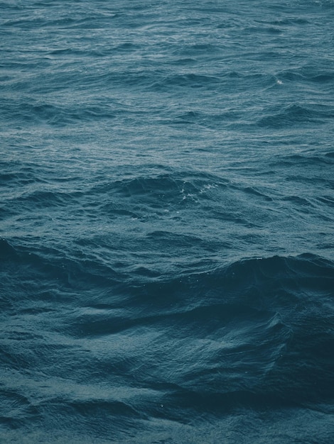 Dark bluegreen color of water surface with waves in middle of\
endless deep sea endless wavy expanse