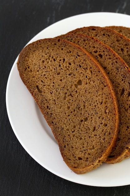 Dark bread on white plate