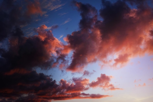 Dark bright pink and purple clouds in blue sky. Sunset or sunrise.